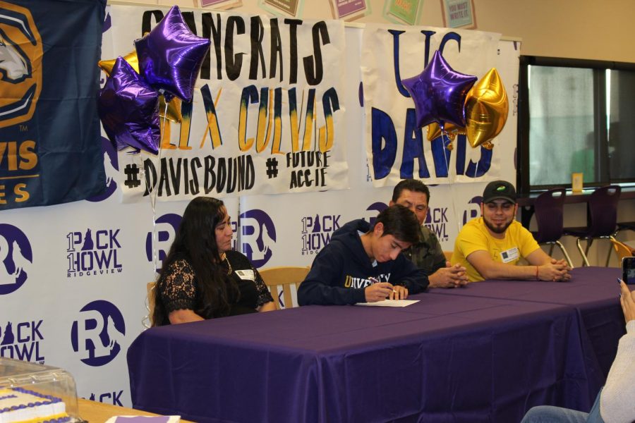 Alex+Cuevas+signs+his+letter+of+intent+to+UC+Davis+as+his+family+looks+on.