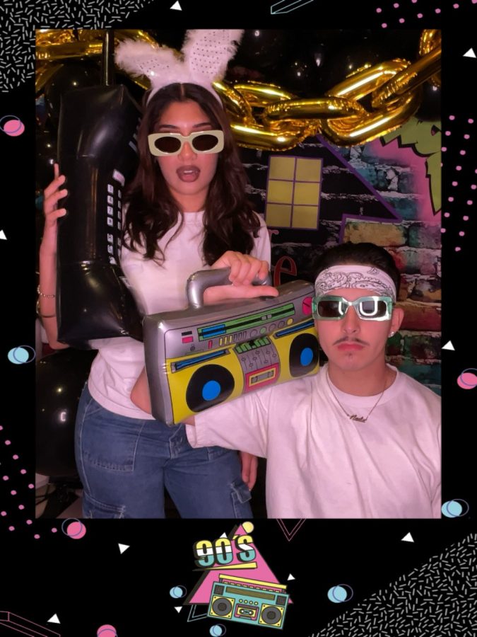 Nadia Brar and Justin Hernandez posing for picture at a 90s themed party.