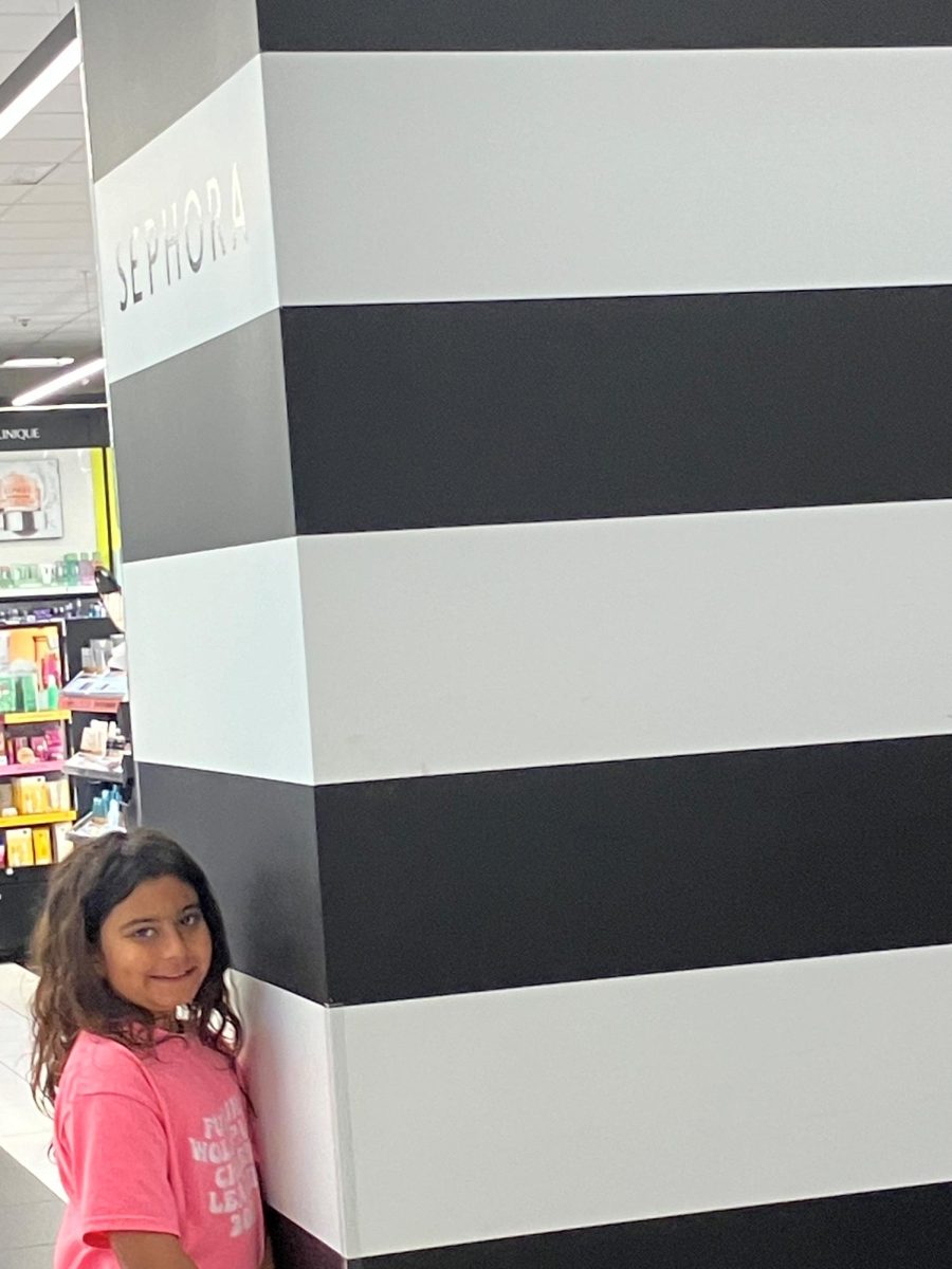 A little girl standing outside the Sephora Store.