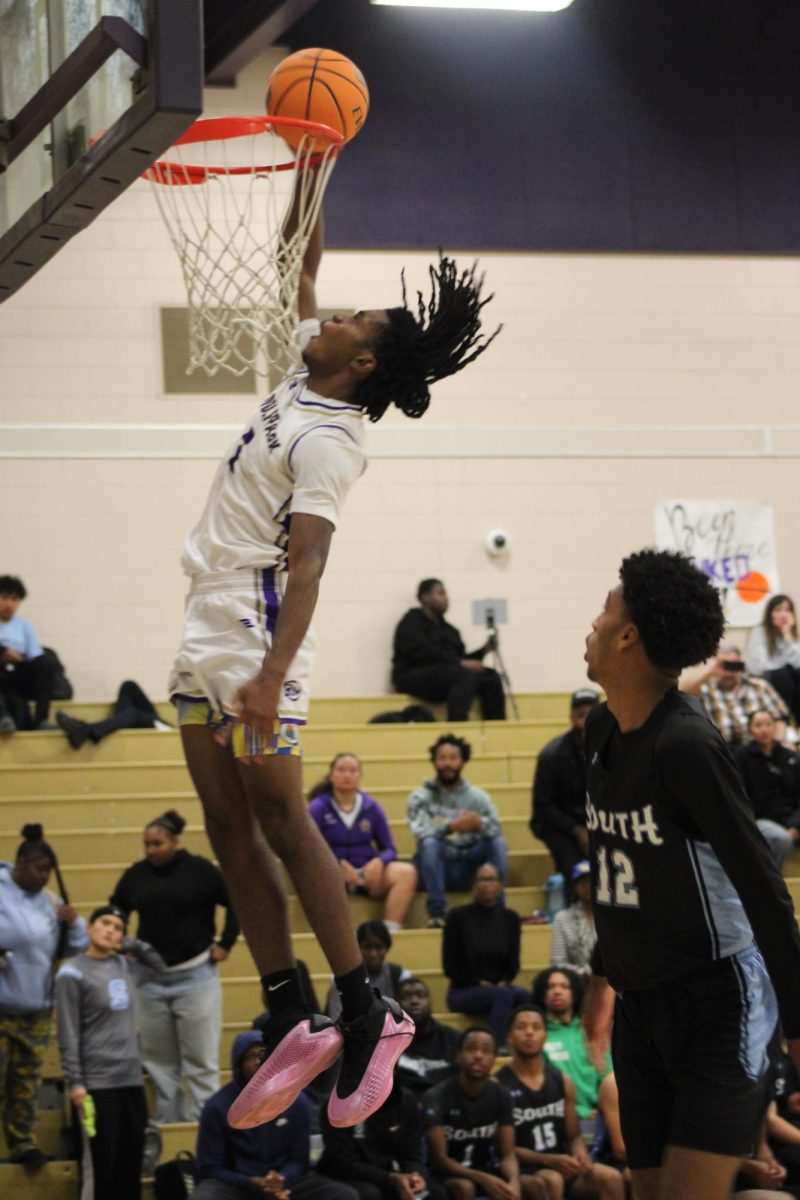 Braylin Herron dunking the ball against their opponent South High school.